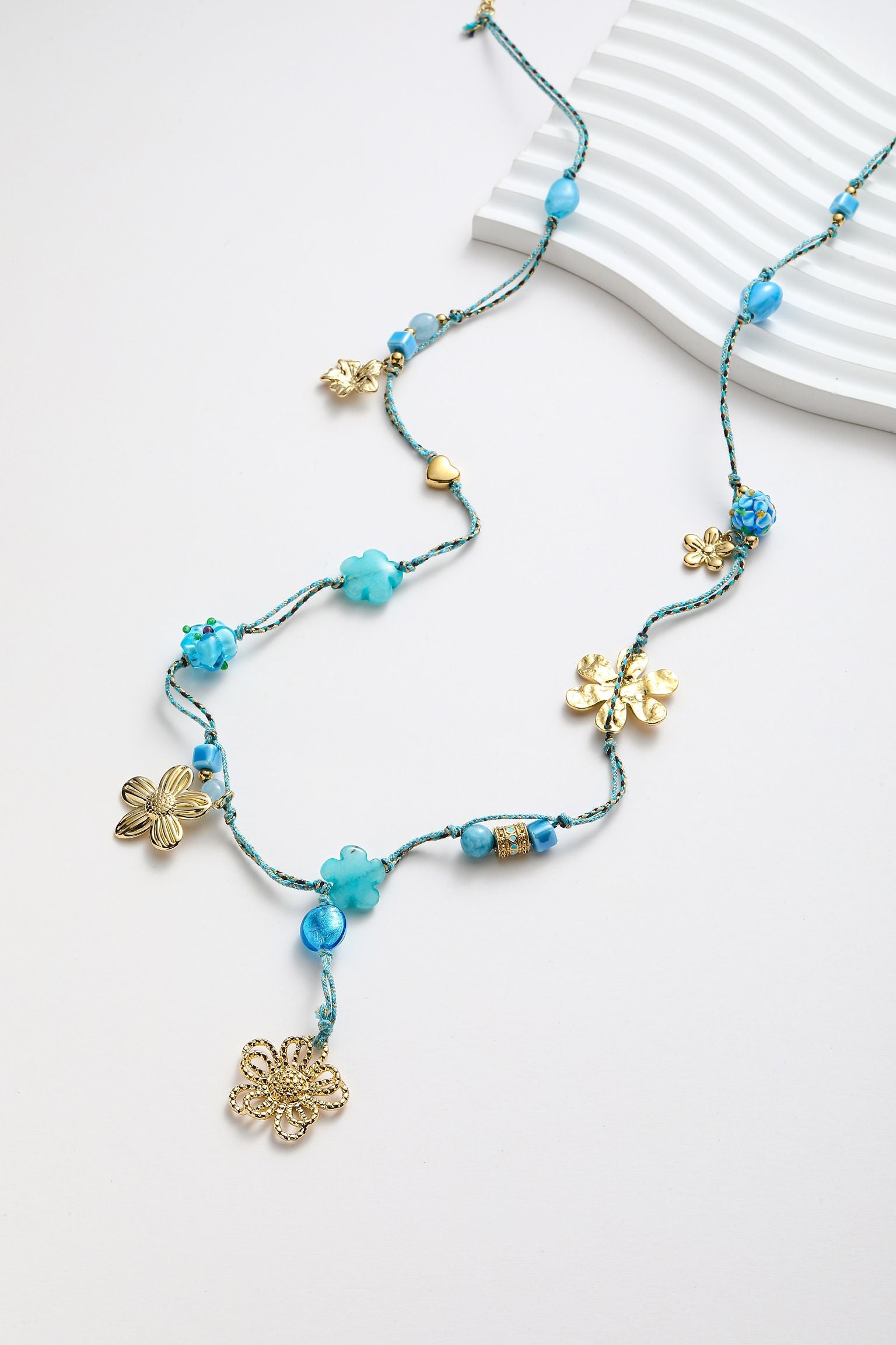 Collana con varie fiori e pedente in corda cerata