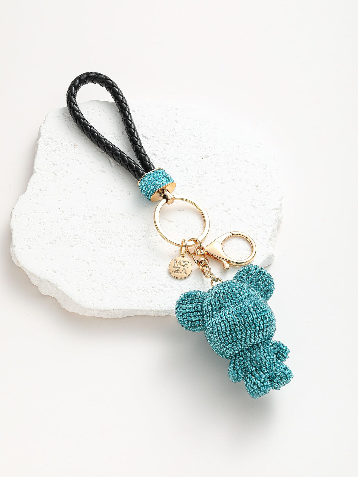 Portachiavi composto da un anello dorato su cui si agganciano due componenti: un adorabile orsetto completamente ricoperto di strass colorato e un manico intrecciato in pelle sintetica.